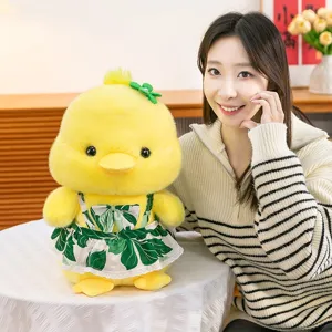 Cute yellow duck plush toy wearing a green leaf print dress with Asian female model