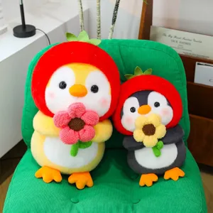 Adorable plush strawberry penguin dolls holding flowers sitting on a green chair
