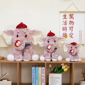 Drie schattige roze olifantenknuffels met rode baretten en appels op een houten plank.