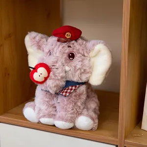 Schattige roze pluche olifant met rode baret en appelaccessoire op een houten plank