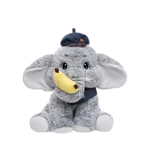 Schattige grijze pluche olifant met een stijlvolle blauwe baret en een zacht bananenspeeltje