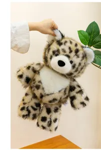 Detailed view of a soft leopard print plush bear toy being held against a plain wall