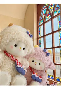 Detailopname van schattige pluche schapenpoppen in crème en roze bij een raam.
