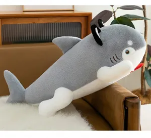Detail shot of a creative shark dog plush pillow resting on a brown leather sofa