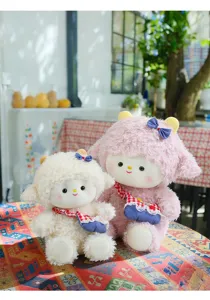 Detailweergave van twee pluche lammetjes, wit en roze, met schattige geruite tasjes.