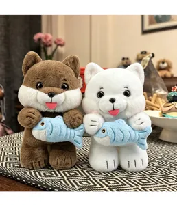 Two adorable cat plush toys holding blue fish in a cozy indoor lifestyle setting
