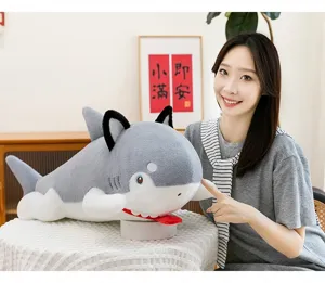 Asian woman holding a cute creative shark-dog plush toy in a cozy home setting