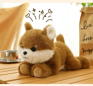 Detailed view of a soft brown and white Shiba Inu plush dog toy lying on a wooden table