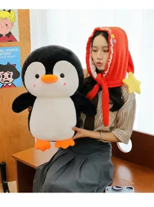 Süßes großes Pinguin-Plüschtier mit passendem rotem Sternenhut, von Model gehalten