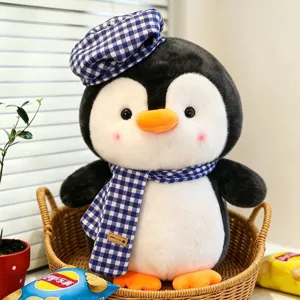 Süßes großes Pinguin-Plüschtier mit blau kariertem Hut und Schal in einem Korb