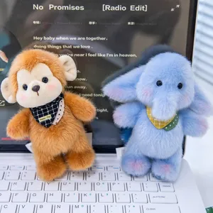 Süße Affen- und Elefanten-Plüschtier-Schlüsselanhänger auf einer Laptop-Tastatur