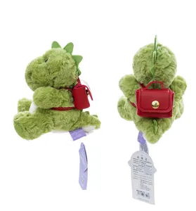 Vista lateral y trasera detallada de un dragón de peluche verde con una pequeña mochila roja