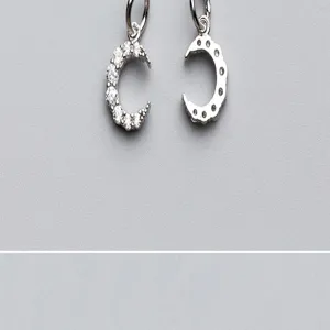 Détail macro de pendentifs en argent 925 en forme de croissant de lune avec pierres