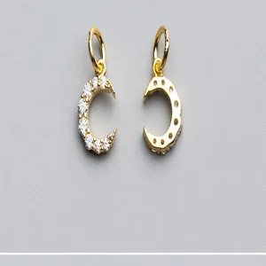 Détail des pendentifs demi-lune plaqués or avec sertissage micro-pavé en zircons.