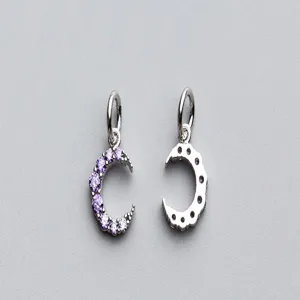 Détail macro de pendentifs demi-lune en argent S925 avec des pierres de zircon violettes