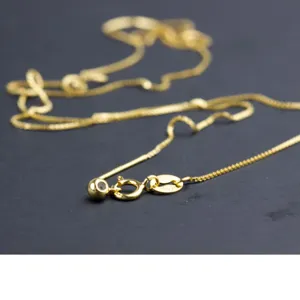 Vista macro di una catena ad ago in argento sterling 925 placcato oro con perla