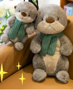 Adorable grey otter plush toy pair wearing green knitted scarves on a leather sofa