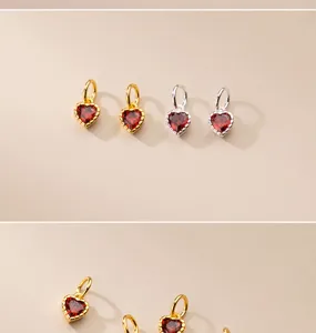 Detailansicht von Mini-Herzanhängern mit rotem Zirkon in Gold- und Silbausführung.