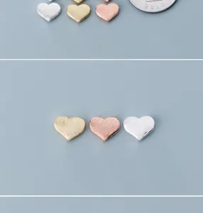 Detailed shot of 925 silver brushed heart spacer beads, ideal for DIY jewelry making.
