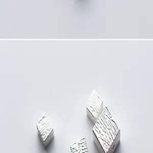 Macro detail of S925 sterling silver cube beads with striped texture for DIY jewelry