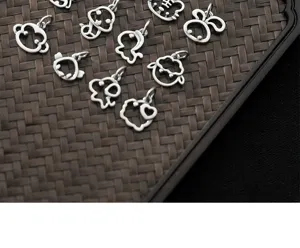 Close-up of S925 matte silver hollowed-out animal charms on a textured tray