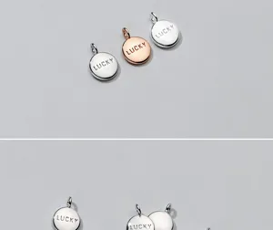 Macro view of polished S925 silver round pendants with engraved LUCKY message details