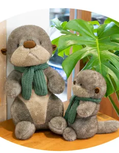 Detailed view of two cute otter plush toys wearing green knitted scarves, large and small sizes