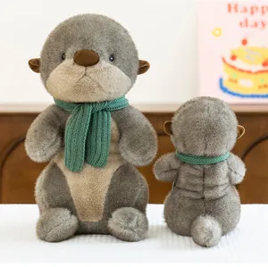 Front and back view of a cute otter plush toy wearing a green knitted scarf.