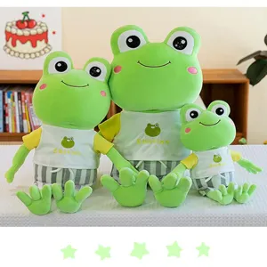 Detailed view of three green frog plush toys wearing cute summer outfits on white.