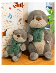 Close-up detail of two cute otter plush toys with green scarves sitting on a wooden table.