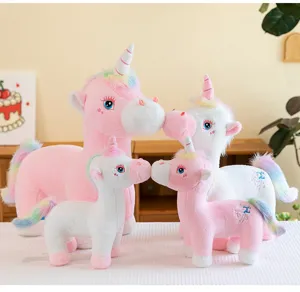 A cozy group of pink and white unicorn plush toys with rainbow manes and tails