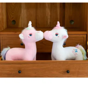 Detailed macro view of pink and white rainbow unicorn plush toys nestled in a wooden drawer
