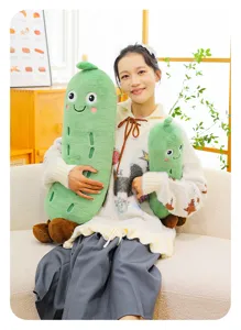 Asiatisches Model hält süße grüne Bittermelonen-Plüschkissen im gemütlichen Heim.