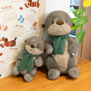 Two ultra-soft cute sea otter plush toys wearing green knitted scarves on wood table