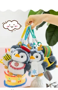 Close-up of four cute plush penguin pendants with different winter accessories held by hand