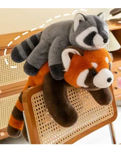 Adorable red panda and raccoon plush toys lying on a wicker chair for cozy home decor.
