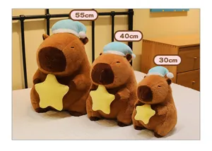 Comparación de tres tamaños de peluches Capybara con estrella y gorro de dormir en cama