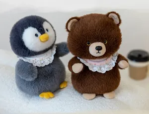 Close-up detail of cute plush penguin and brown bear dolls with delicate lace collars.