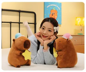 Peluche de carpincho con gorro de dormir sosteniendo una estrella y luna en el dormitorio.