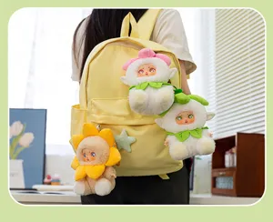 Vue détaillée de mignons porte-clés en peluche bébé fleur sur un sac à dos jaune.