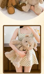 Ours en peluche beige mignon avec un nœud assorti tenu par un mannequin en détail