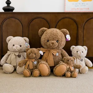 Collezione di teneri orsetti di peluche con grandi fiocchi in marrone e beige caldo