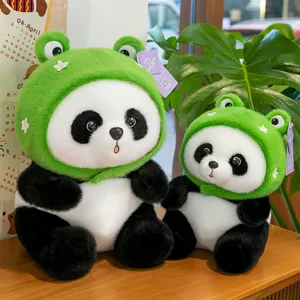 Zwei süße Panda-Plüschtiere mit grünen Frosch-Kapuzenpullovern auf einem Holztisch