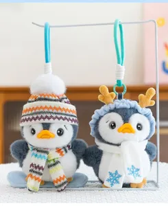 Pair of cute plush penguin charms wearing knitted winter hats and festive scarves