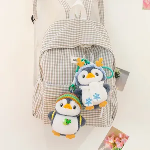 Cute plush penguin keychains with colorful winter hats used as decorative backpack charms
