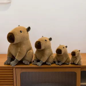 Cuatro peluches de capibara de varios tamaños exhibidos en un mueble de madera rústica
