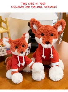 Detailed shot of two cute fox plush toys in red hoodies on a wooden table