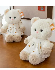 Detailed view of two adorable white cat plush toys wearing floral lace dresses on wood table