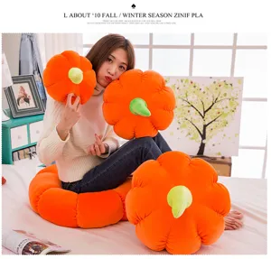 Asian model displaying different sizes of soft orange pumpkin plush pillows in a cozy bedroom