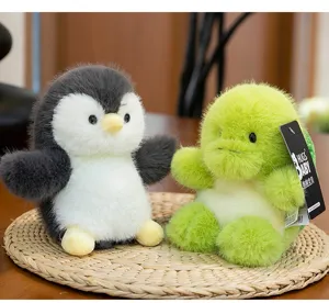 Close-up of two fuzzy puff penguin and green plush toys with soft fur texture